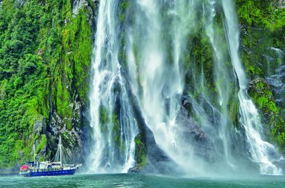 El parque nacional de Fiordland abarca un rincón montañoso de la isla Sur de Nueva Zelanda. Sierras, valles glaciares, lagos y fiordos componen su paisaje en buena parte virgen. Se puede recorrer a través de tres grandes senderos señalizados, navegar sus ríos en kayak y dormir en cabañas típicas. En la foto, un barco turístico en Milford Sound.