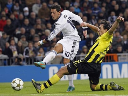 Özil golpea el balón ante el jugador del Borussia Mats Hummels.