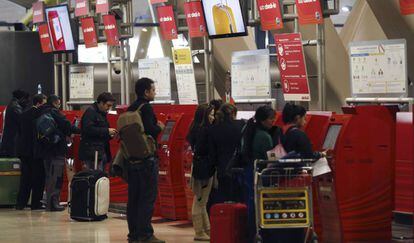 Varias personas, en los mostradores de facturaci&oacute;n de Iberia de la T4 del aeropuerto de Madrid-Barajas. 