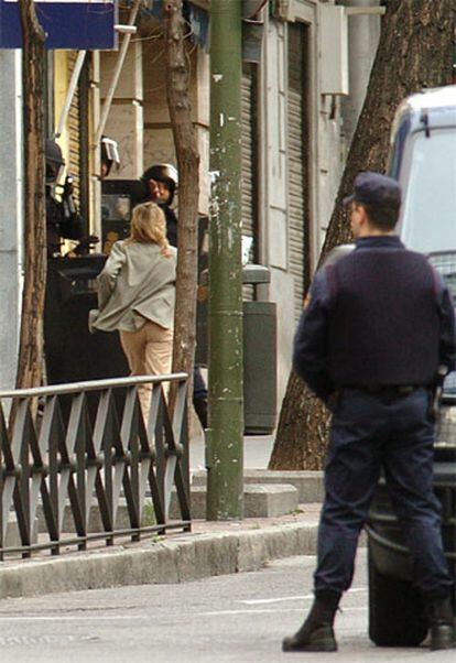 Una mujer corre hacia la Policía tras ser liberada por los dos hombres que atracaron una sucursal del BBVA en Madrid.