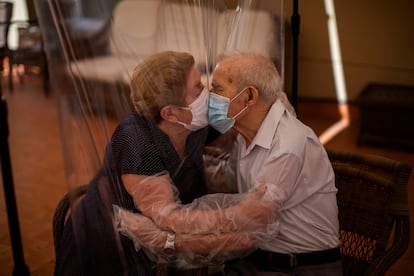 Agustina Cañamero, de 81 años, y Pascual Pérez, de 84, se abrazan y besan a través de una pantalla de película plástica para evitar contraer el nuevo coronavirus en un asilo de ancianos en Barcelona, España, el lunes 22 de junio de 2020,en el centro de ancianos Ballesol Fabra i Puig.