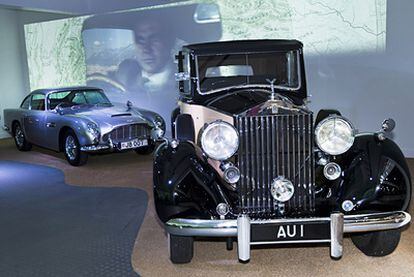 El Rolls-Royce Phantom III que utilizaba Goldfinger, en el film del mismo nombre, para contrabandear el oro. Al fondo el Aston Martin DB5, mejor conocido como el coche Bond por la matrícula personalizada con los datos del agente 007.