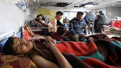 Varios palestinos que resultaron heridos al disparar el jueves el ejército israelí contra una multitud que intentaba recoger alimentos de un convoy de camiones en la Franja, son atendidos este viernes en el hospital Al Shifa, en Ciudad de Gaza.