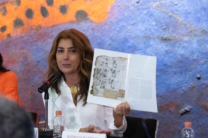 María Castañeda, doctor in History, shows a book that compiles research on the codices and their photographs.