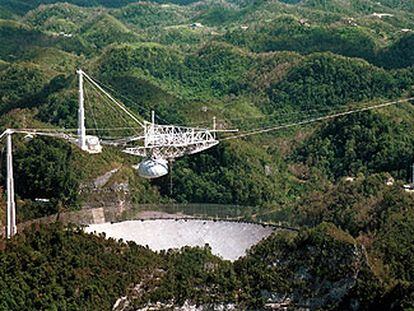 La antena de 305 metros de diámetro del radiotelescopio de Arecibo (Puerto Rico) está montada entre montañas (izquierda).