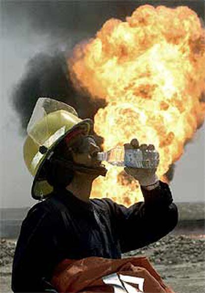 Un bombero kuwaití bebe agua al lado de un pozo incendiado en Rumaila, al sur de Irak.