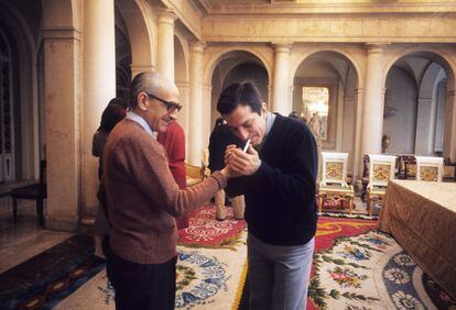 El general Manuel Gutiérrez Mellado enciende el cigarrillo del presidente del Gobierno, Adolfo Suárez, en una distendida imagen en la que visten de modo informal y que fue tomada en el palacio de la Moncloa antes de la misa de domingo el 1 de junio de 1977.
