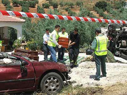 Cuatro operarios trasladan los cuerpos de los fallecidos en un accidente en Cabra (Córdoba).