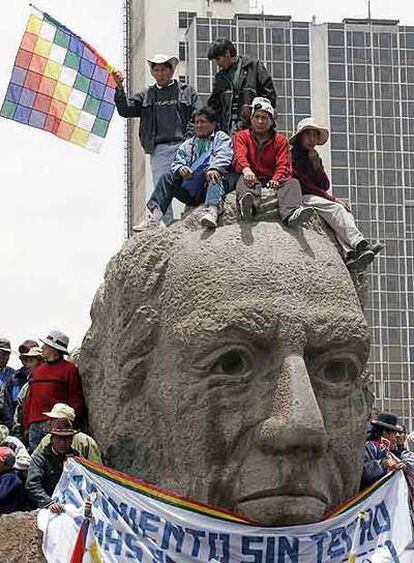 Un grupo de indígenas, sobre la estatua de un héroe boliviano en La Paz.