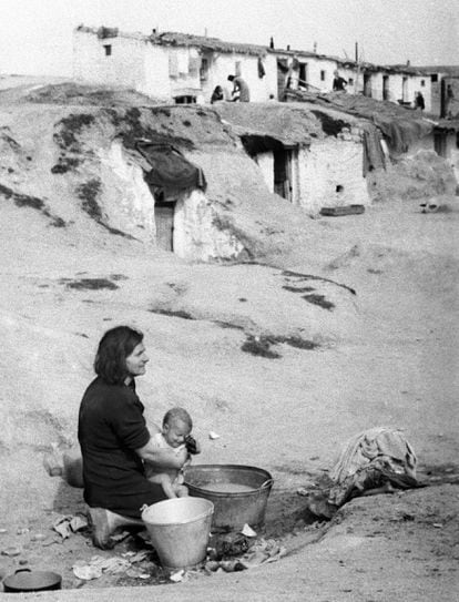 Una mujer baña a su hijo en un balde en un barrio de chabolas a las afueras de Madrid, en 1940.

