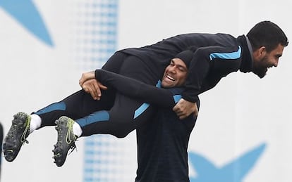 Arda Turan, el último fichaje azulgrana, se divierte con Alves en el entrenamiento del Barcelona.