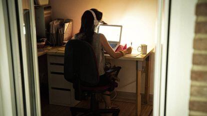 Una mujer escucha archivos de sonido desde su ordenador. 