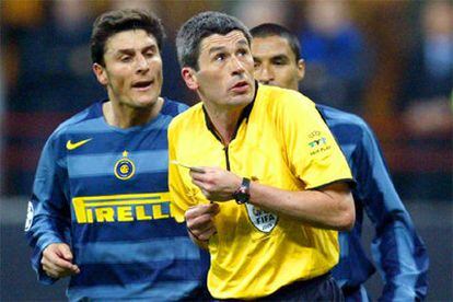 El árbitro, Markus Merk, se muestra asustado ante los hechos mientras es increpado por Javier Zanetti.