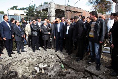 El grupo de observadores de la Liga Árabe contempla el lugar donde explotó un coche bomba ayer en Damasco.