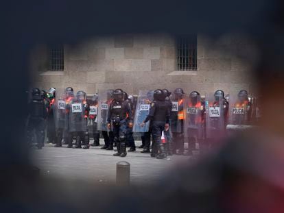 Elementos de la policía con equipo antidisturbios, observados a través de un orificio en las barricadas que se colocaron frente a Palacio Nacional.