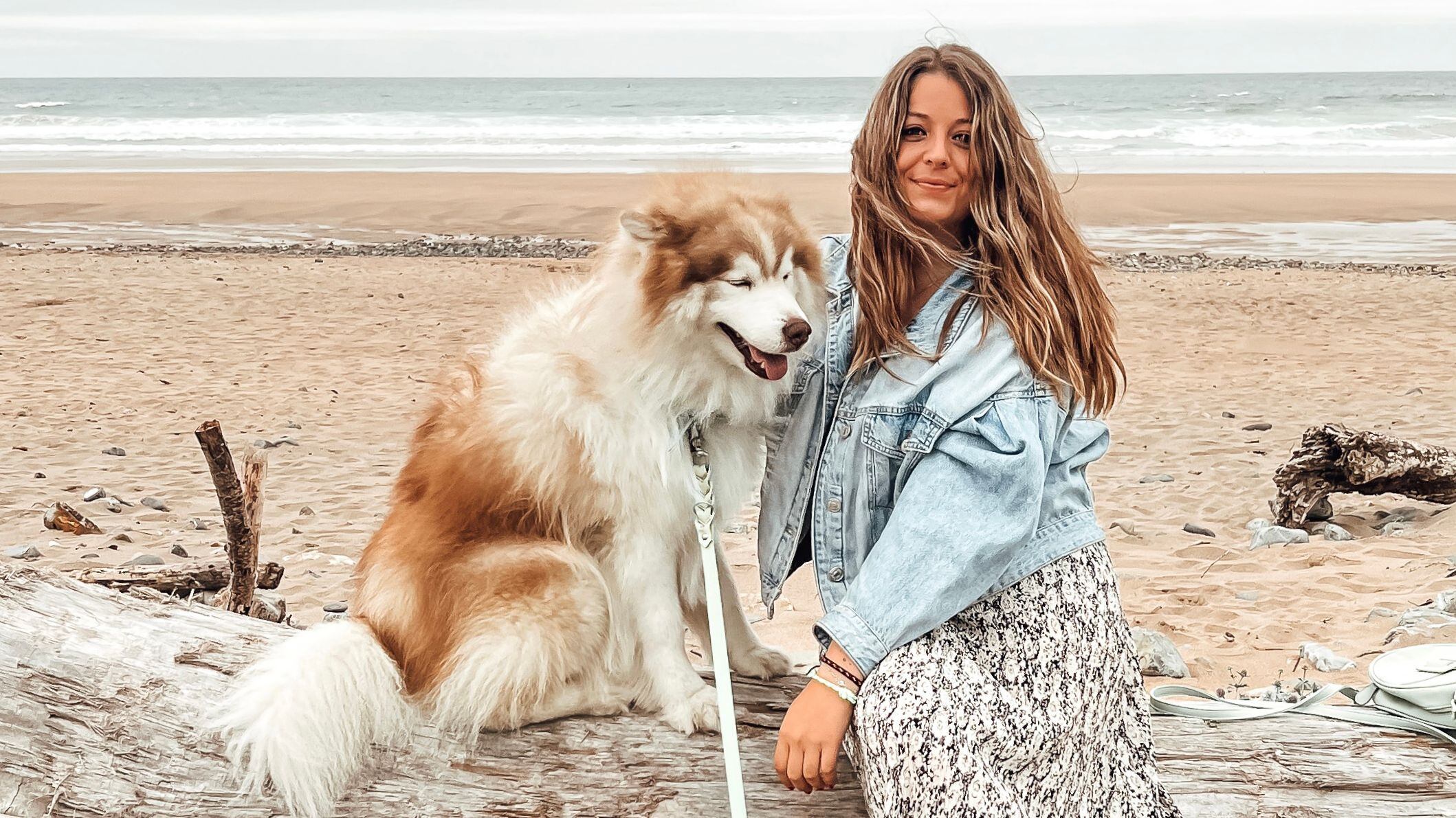 Patricia Fernández, creadora de contenido, y su perro 'Brus', en la playa de Vega (Asturias), en una imagen cedida. 