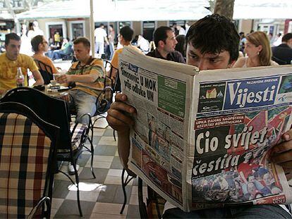 Un hombre lee un periódico con el titular "El mundo entero se congratula", ayer en Podgorica.