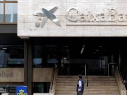 Un hombre observa el logo de Caixabank.