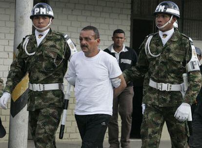 El guerrillero Gerardo Antonio Aguilar, alias 'César', escoltado por agentes de las fuerzas de seguridad colombiana