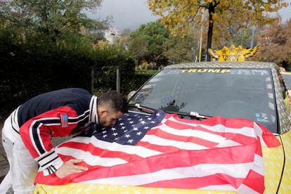 Un taxista partidario de Trump besa la bandera estadounidense.