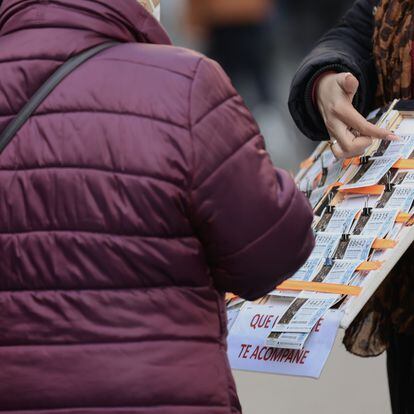Una mujer compra un décimo de lotería a una vendedora ambulante, tres días antes del Sorteo de La Lotería del Niño, a 3 de enero de 2022, en Madrid, (España).