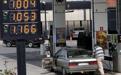 Un hombre reposta carburante en su coche en una estaci&oacute;n de servicio.