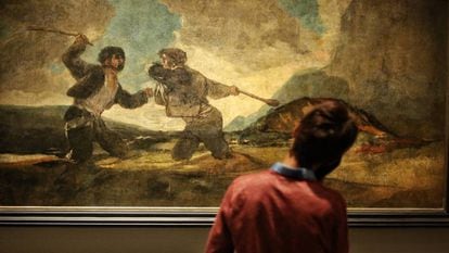 Un visitante contempla la obra 'Duelo a garrotazos', de Goya, en la sala de las pinturas negras del Museo del Prado.