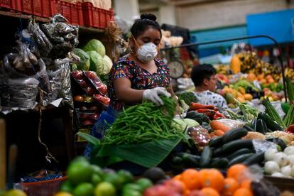 Una mujer vendedora de vegetales en un mercado de ciudad de Guatemala.