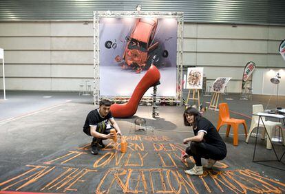 Jon Elorrieta y Saioa Aresti, estudiantes de Bellas Artes de la UPV, trabajan en el pabellón que el colectivo artístico Antikythera ha instalado en la Bienal de Máquina Herramienta en el BEC.