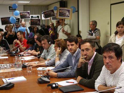 El socialista Denis Itxaso (segundo por la derecha), y el portavoz popular en San Sebastián, Ramón Gómez Ugalde (a su derecha), ayer en la junta de San Marcos. Al fondo, partidarios de Bildu.