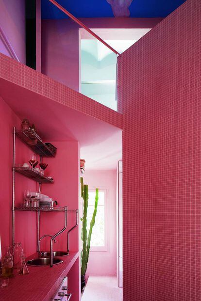 La cocina, hecha de gresite rosa y estantes Metro.