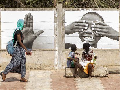 Los transeuntes observan las fotos de la exposición Je suis lá en Dakar, Senegal.