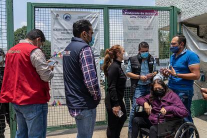 Omar Hernández recibe información junto a su madre, en silla de ruedas, en la entrada del Hospital General de Atizapán.
