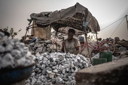Asiatu, otra de las mujeres desplazadas que se dedica a la extracción de granito como medio de subsistencia, pica piedra bajo su tienda improvisada con palos y telas.