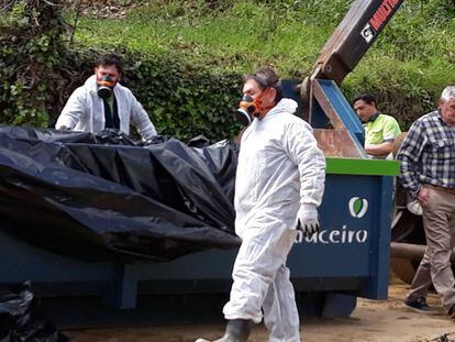 Trabajadores de la empresa que realiza las obras municipales de saneamiento recogen la tierra contaminada con mascarillas.