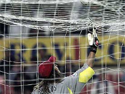 Burgos se dispone a recoger el balón, caído sobre su red.