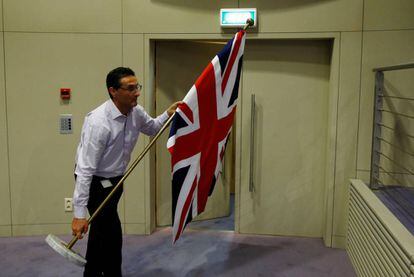 Un funcionario coloca la bandera brit&aacute;nica para la rueda de prensa de los negociadores del &#039;brexit&#039;. REUTERS/Francois Lenoir