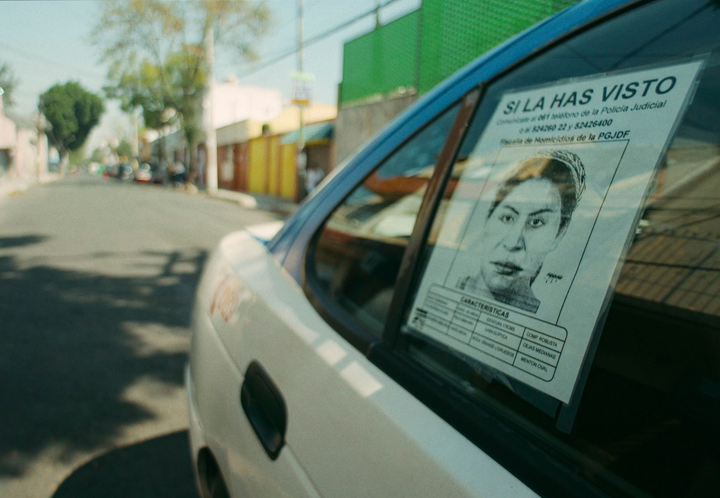 Un cartel de búsqueda de 'la Mataviejitas' en la ventana de un auto.