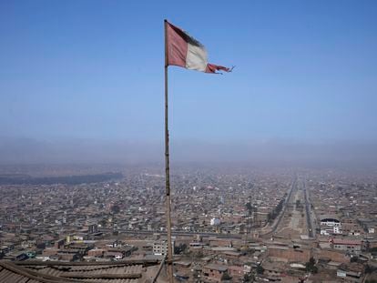 Una bandera peruana ondea desde el techo de un comedor de beneficencia local en el barrio de Villa María de Lima, Perú.