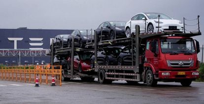 Un camión transporta coches nuevos de Tesla frente a la fábrica de la compañía en Shanghái, China.
