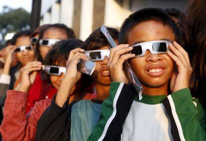 Escolars contemplen l'eclipsi solar a Jakarta (Indonèsia).