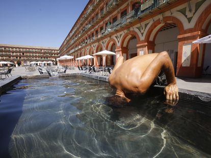 Un hombre mete la cabeza en la fuente de la plaza de la corredera de Córdoba el 3 de agosto, en plena tercera ola de calor de este verano.