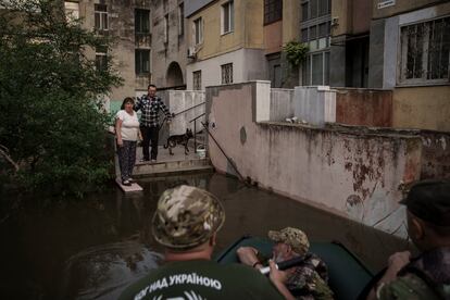 Dos vecinos hablan con un grupo de militares en el exterior de un bloque de viviendas en la ciudad de Jersón, el miércoles.