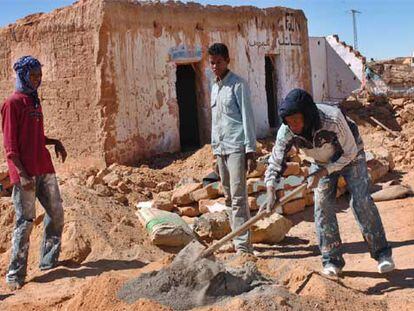 Saharauis trabajan en la reconstrucción de sus casas, arrasadas por las lluvias, en los campos de Tinduf.