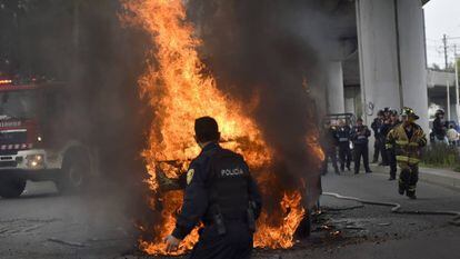 Un policía frente a los microbuses incendiados el pasado 20 de julio en Tláhuac tras el operativo militar contra El Ojos.