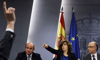 Santamaría, entre Guindos y Montoro,   concede el  turno a un periodista durante la rueda de prensa del Consejo de Ministros.