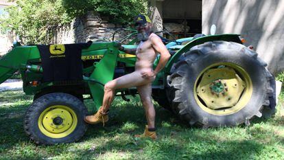 El concejal Pablo Febrero posa desnudo ante el tractor del pueblo. Su fotografía acompaña al mes de diciembre y cierra el almanaque.