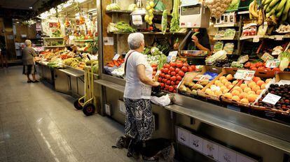 Una se&ntilde;ora compra en una fruter&iacute;a del mercado de Ant&oacute;n Mart&iacute;n (Madrid).