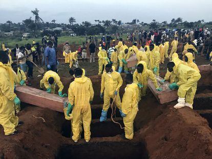 Voluntarios entierran ataudes durante un funeral masivo en Freetown (Sierra Leona) por las víctimas de las inundaciones y aludes de barro, el 17 de agosto de 2017.
