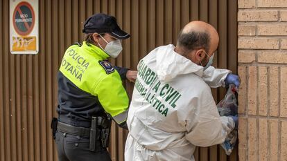 Un agente de la unidad criminalística de la Guardia Civil y uno de la Policía Local de Totona (Murcia) cierran el garaje de la calle de la Rambla número 7 donde el miércoles 9 de febrero apareció el cadáver de Claudia Abigail.
